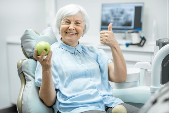 Vanha nainen pitelee omenaa